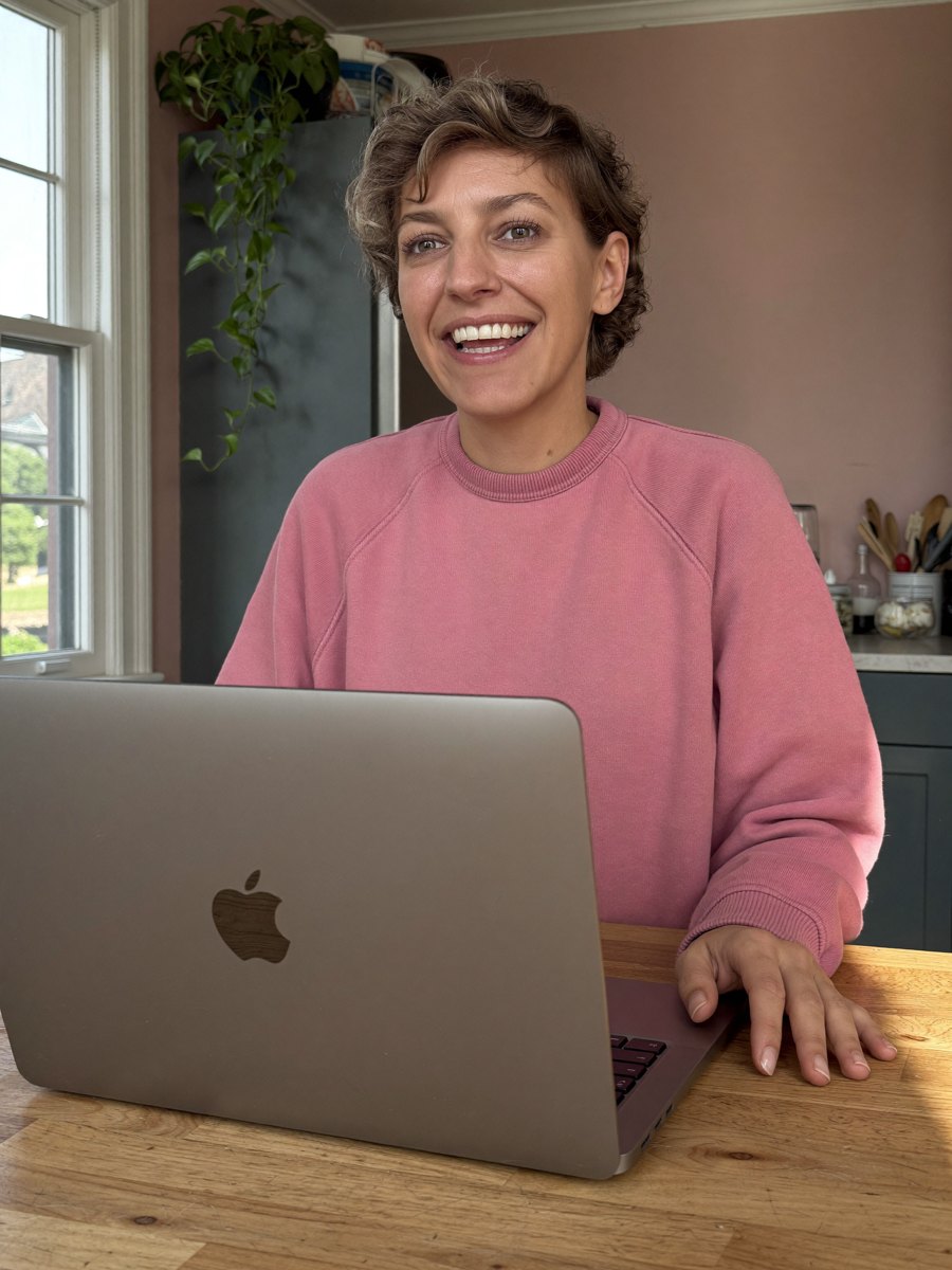 Sofie in roze sweater aan haar laptop