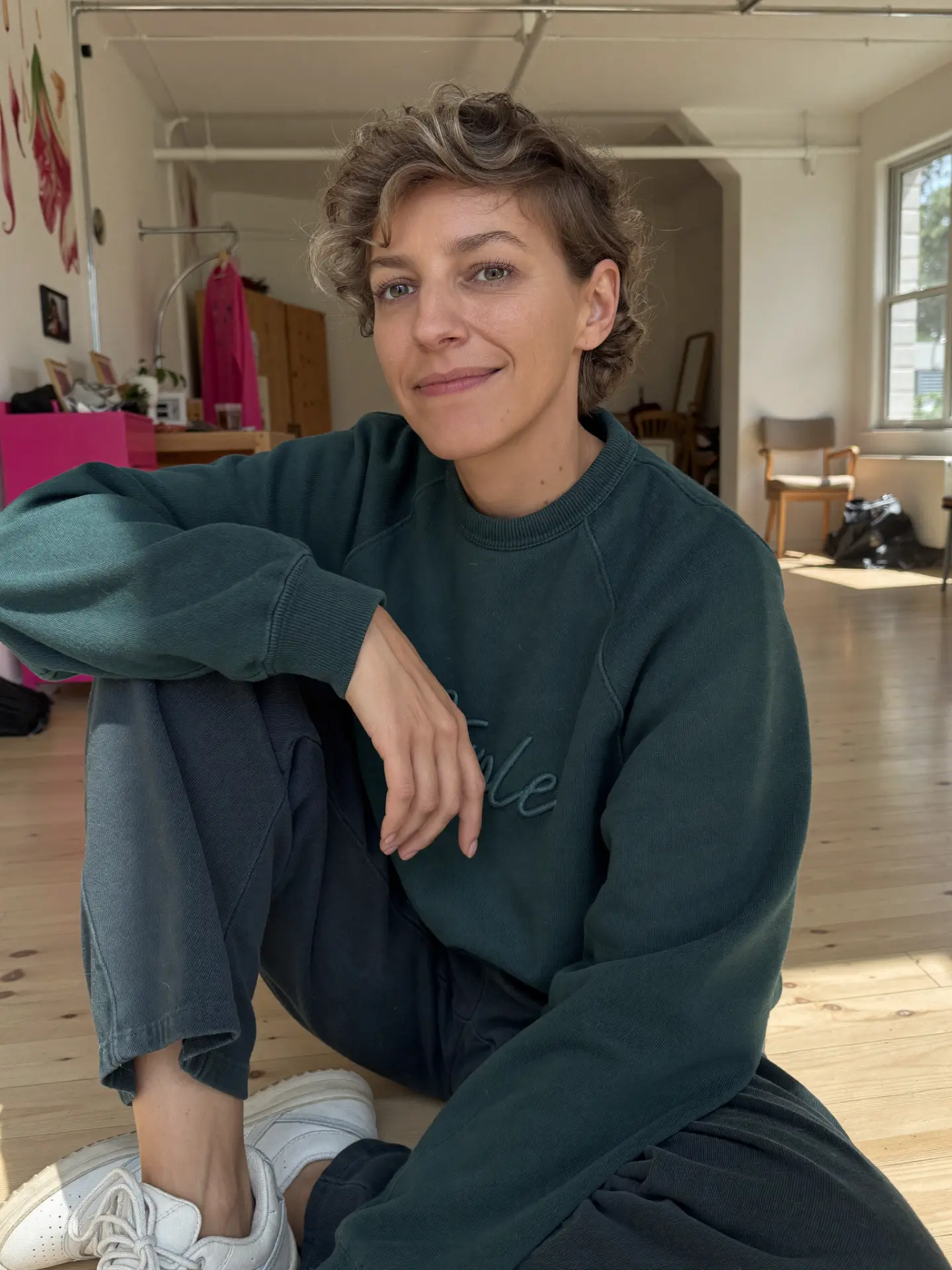 AI brandfoto van Sofie in donkergroene sweater, zittend op de vloer